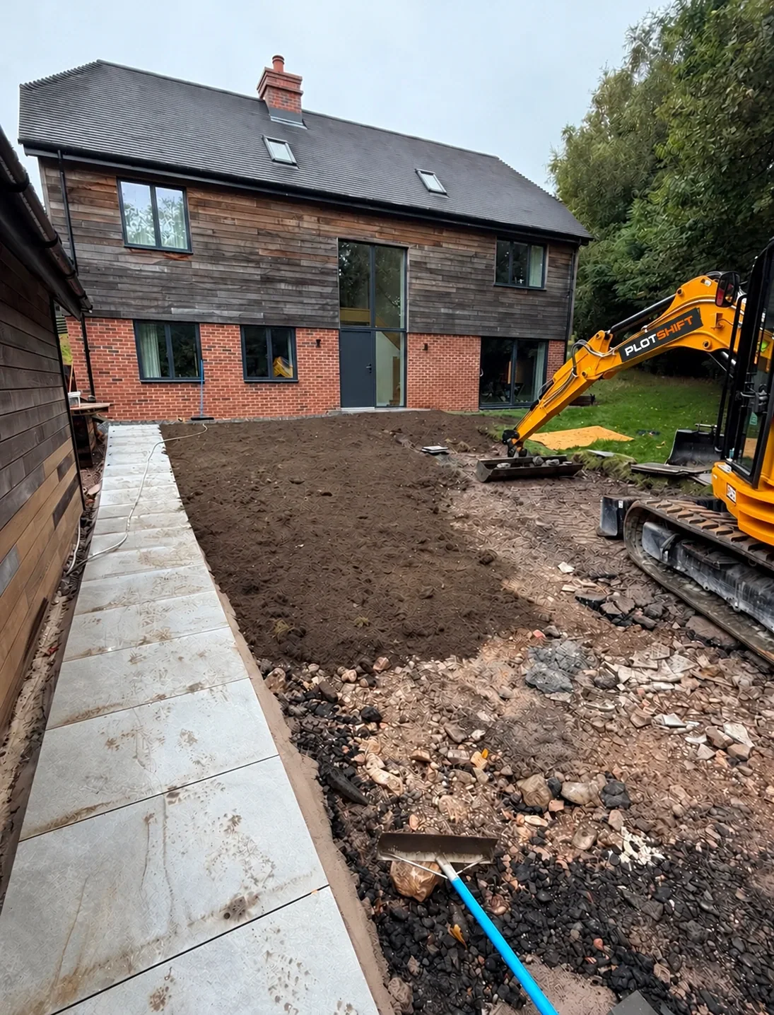 Compact excavator beside newly prepared ground at a UK home