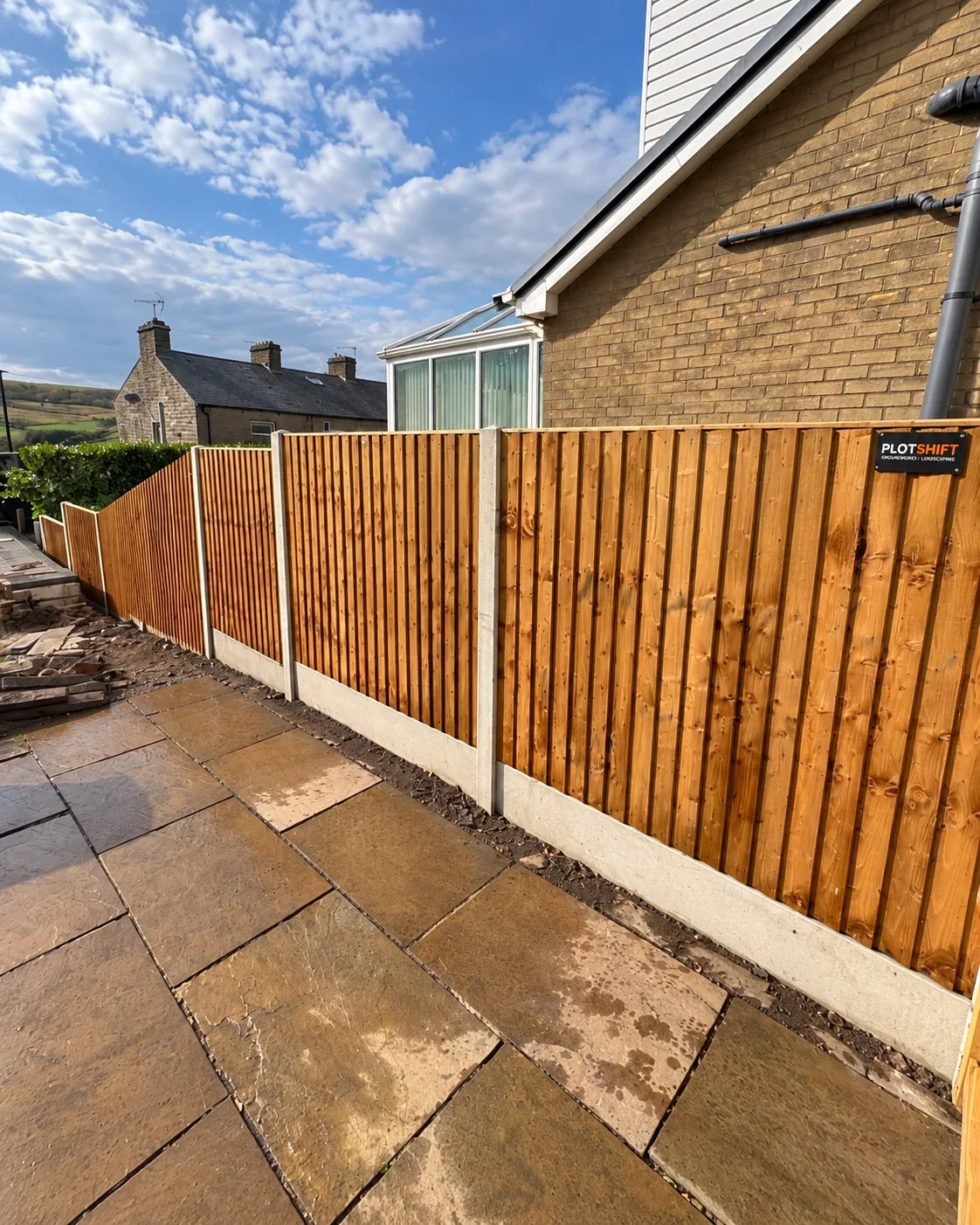 New timber fence panels with concrete posts and gravel boards beside a patio